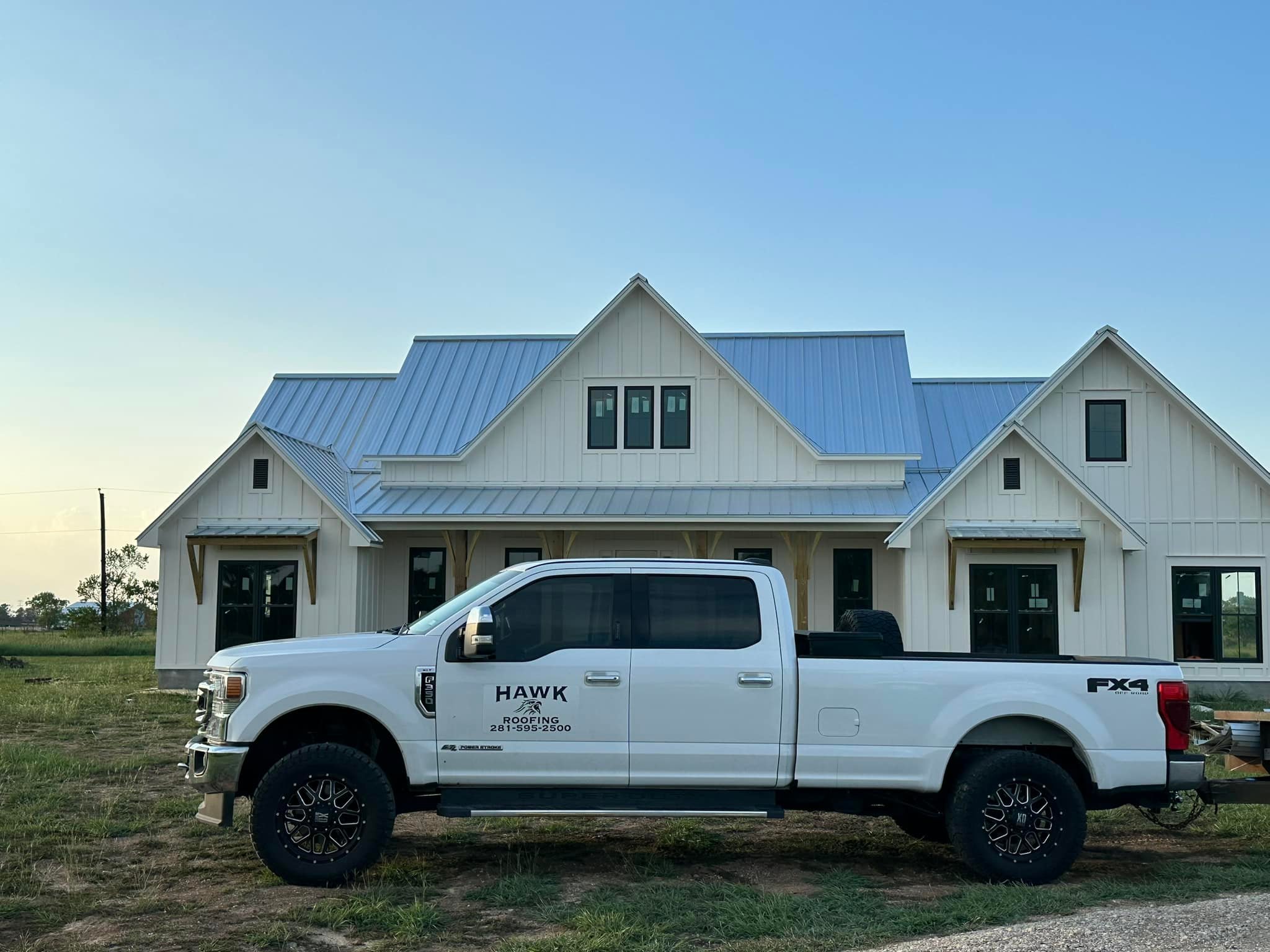 A Hawk Roofing service vehicle parked in front of a customer's home